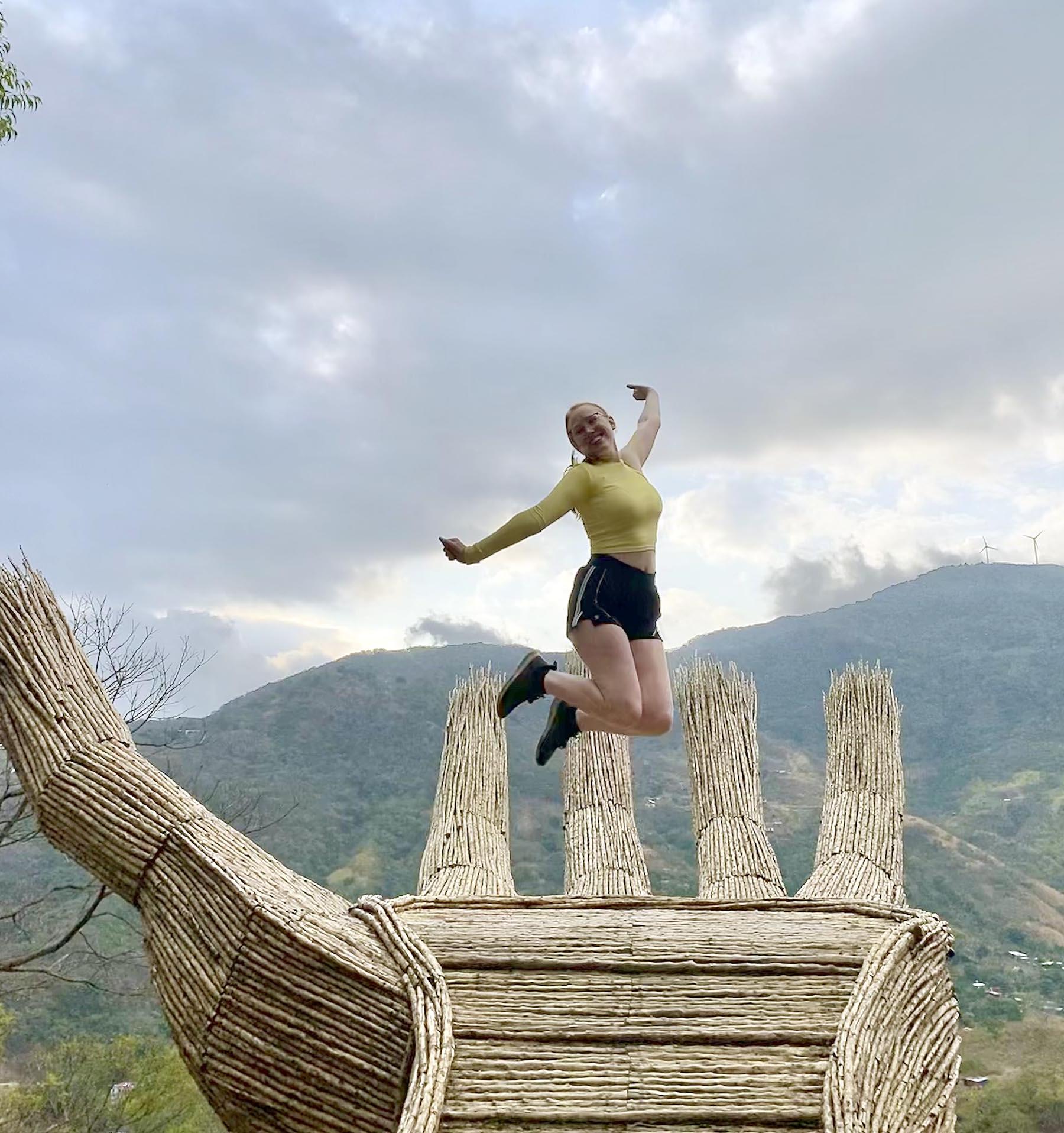 Ashley Hipnar jumps in the air with the Costa Rican mountains in the background