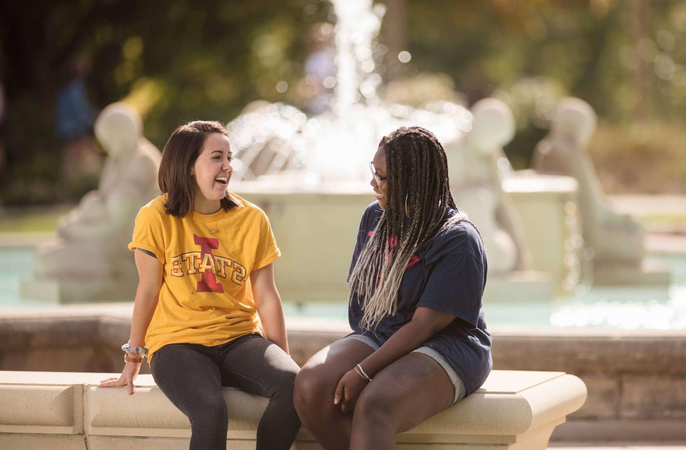 Two students sitting by the Fountain of the Four Seasons